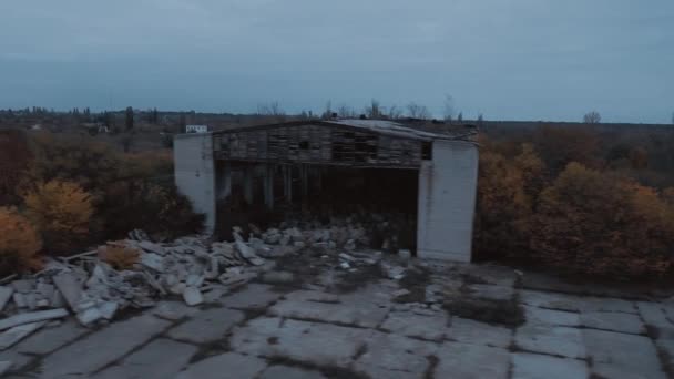 Fliegen Sie über einem zerstörten Militärhangar, in dem lange Zeit kein Mensch war - Filmmaterial, Video