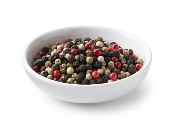 Pepper mix in a plate. Black, red, white, and green peppercorns on a white background - Photo, Image