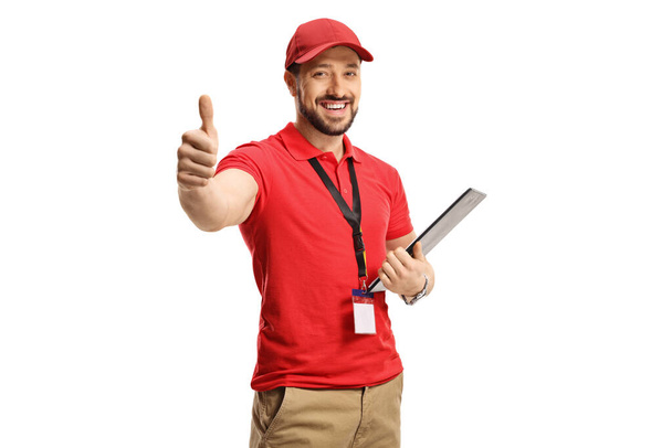 Male shop assistant gesturing a thumb up sign isolated on white background - Foto, Imagen
