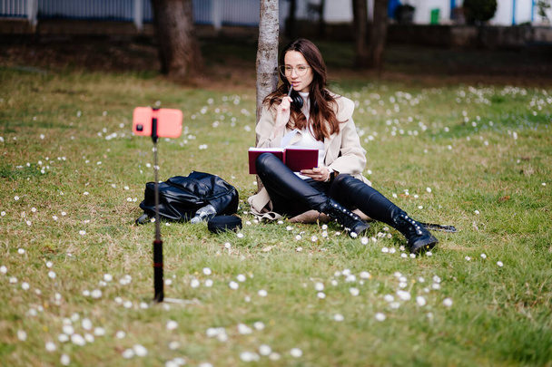 sorridente estudante do sexo feminino aprendendo remotamente ao ar livre no parque - Foto, Imagem