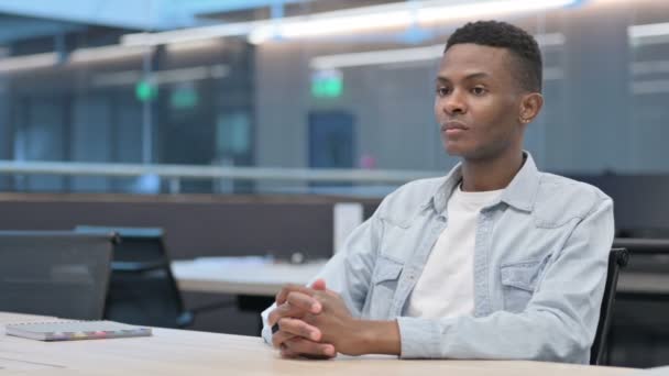 Afrikaanse man zit in het kantoor, ontspannen - Video