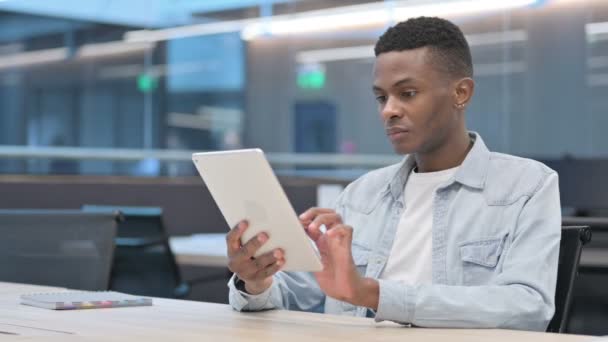 Ελκυστικός Αφρικανός που χρησιμοποιεί tablet στο γραφείο  - Πλάνα, βίντεο