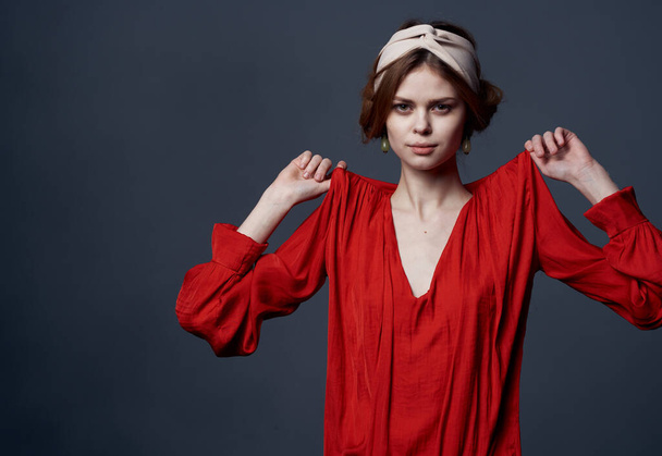 Приваблива жінка в червоній сукні, що прикрашає тюрбан на голові студії обрізаний вид
 - Фото, зображення