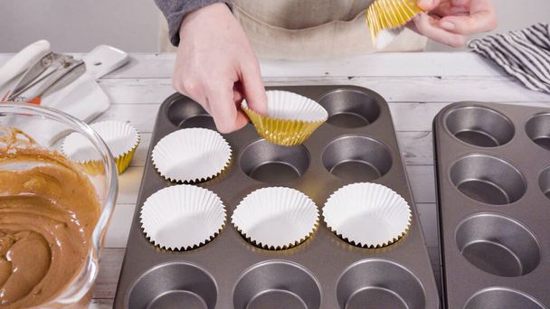 Cupcake pan bekleed met folie cupcake cups om chocolade framboos cupcakes bakken. - Foto, afbeelding