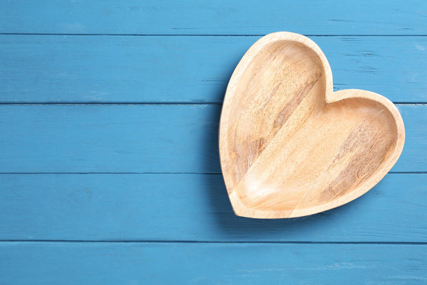 Empty heart shaped wooden plate on blue table, top view. Space for text - Fotografie, Obrázek