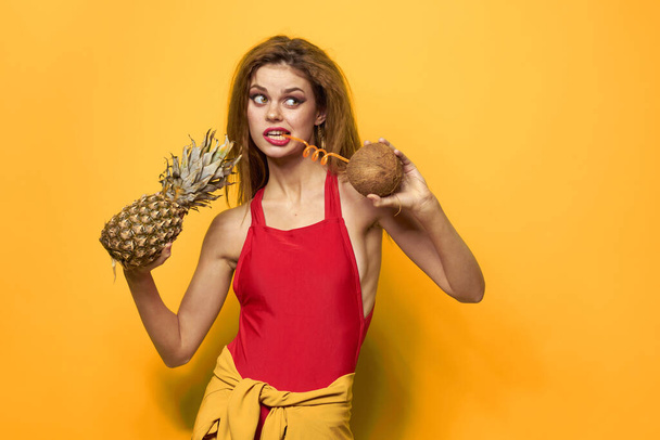 woman with pineapple and coconut cocktail exotic fruits summer lifestyle yellow background - Photo, Image