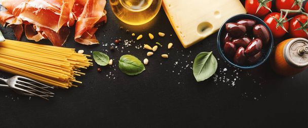 Traditional italian food background with spaghetti tomatoes cheese olives and oil on dark background.  Banner - Foto, afbeelding