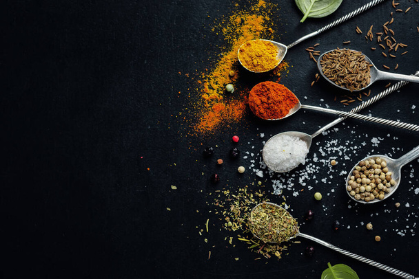 Tasty colorful spices in spoons on dark background. Top View.  - Foto, Bild