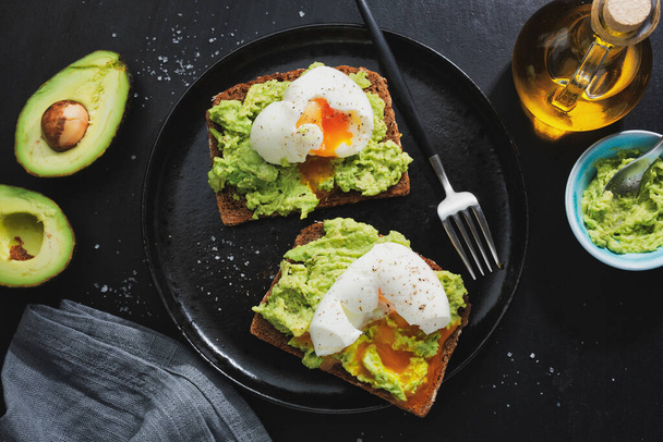 Toasts with avocado and eggs served on plate. Closeup.  - Foto, imagen