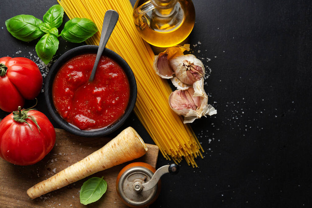 Italian food background with spaghetti vegetables and tomato sauce on dark background. Top View.  - Foto, imagen