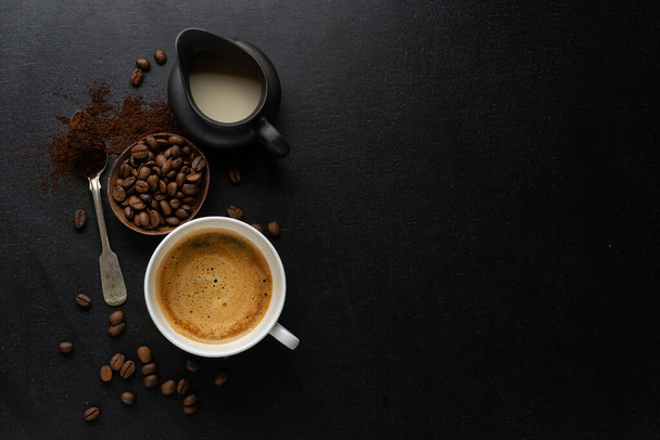 Coffee background with coffee beans, coffee and spoon on dark background. View from above. Coffee concept.  - Foto, Imagen