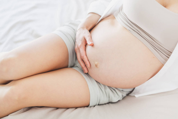 Pregnant woman sitting on bed. Lifestyle. Maternity concept.  - Foto, Bild