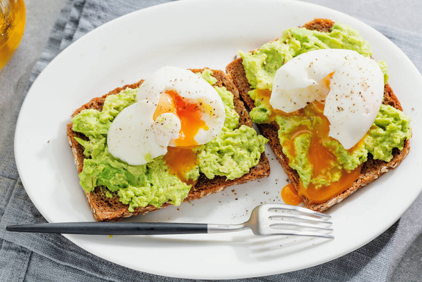 Toasts with avocado and eggs served on plate. Closeup.  - Φωτογραφία, εικόνα