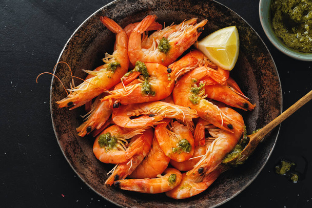 Tasty shrimps with spices and sauce on pan on dark background. Top View.  - Фото, зображення