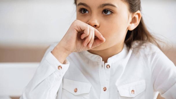 Pensive child in white shirt looking away  - Foto, afbeelding