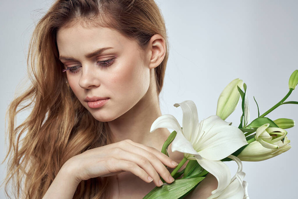 Emotional woman with flowers spring model naked shoulders clear skin - Zdjęcie, obraz
