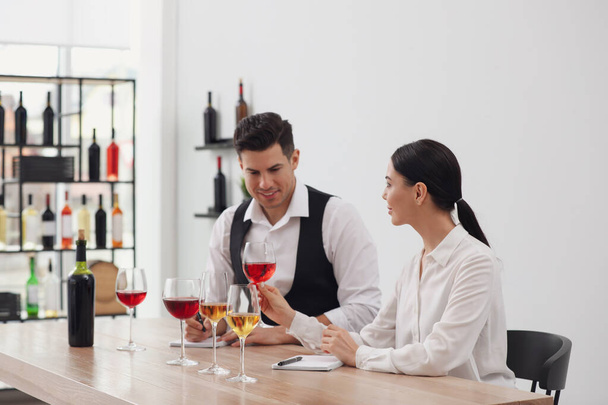 Sommeliers tasting different sorts of wine at table indoors - 写真・画像