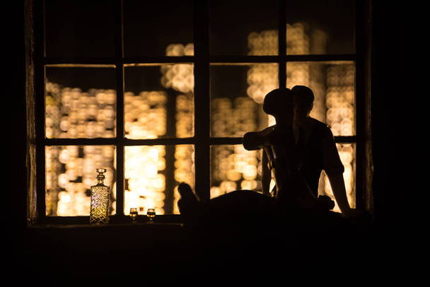 Prachtig uitzicht op een miniatuurstad 's nachts vanuit het raam van poppenhuis. Romantisch stel bij het raam. Kunstwerk tafeldecoratie met handgemaakte realistische poppenhuis. Selectieve focus. - Foto, afbeelding