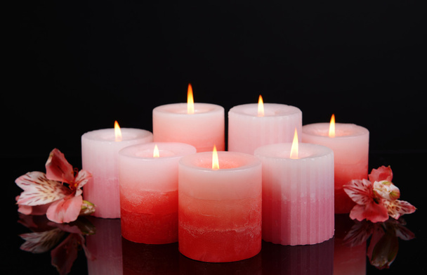 Beautiful candles with flowers isolated on black - Foto, afbeelding