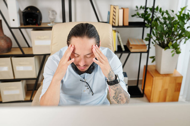 Empreendedor sofrendo de dor de cabeça depois de trabalhar em grande projeto durante todo o dia sem pausas - Foto, Imagem
