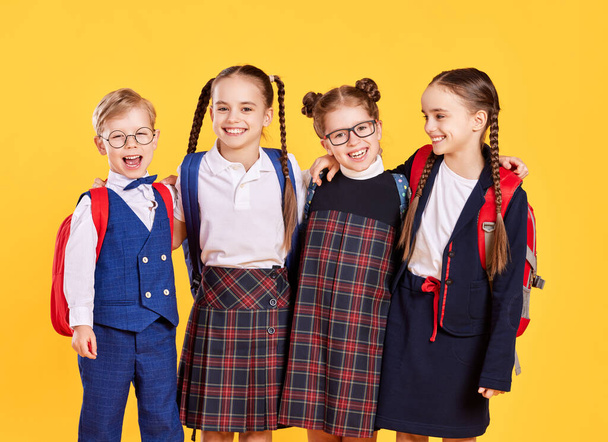 Смешно счастливая группа детей студент и девочки о желтом фоне - Фото, изображение
