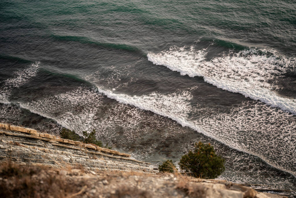 Foamy sea waves break on the shore, beautiful landscape and nature background. Shot from above - Photo, Image