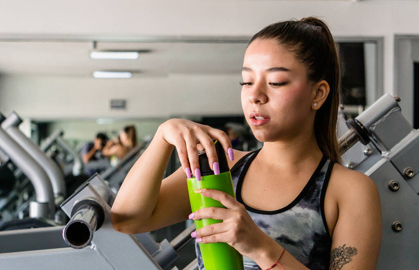 woman in gym opening water container - Photo, Image