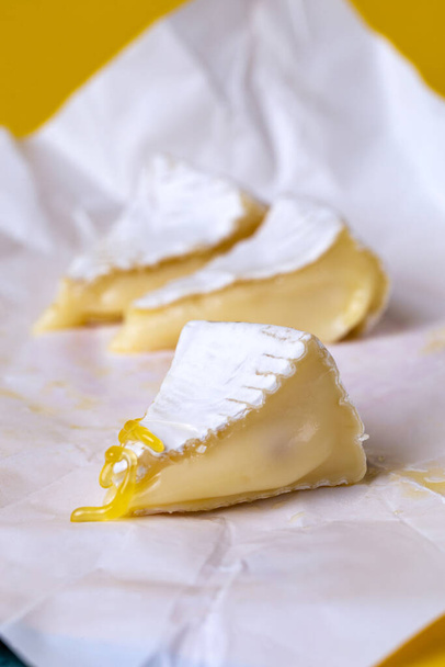 camembert-juusto hunajalla valkoisella paperilla - Valokuva, kuva