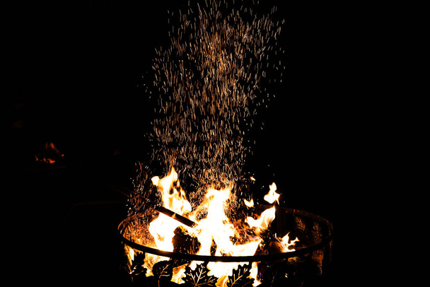 Спарки летять з багаття у вогняній чаші в нічне небо
 - Фото, зображення