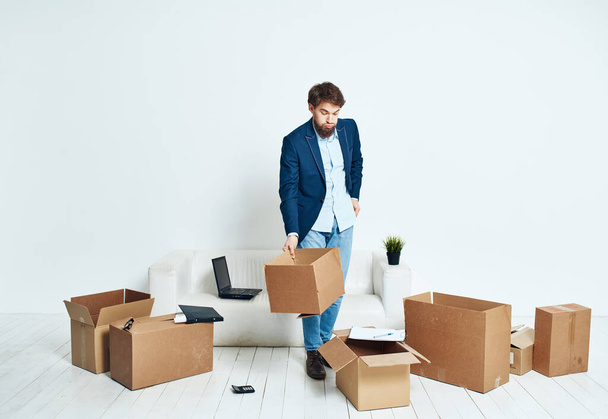 Uomo d'affari in una tuta scatole in mano raccogliendo le cose in movimento - Foto, immagini