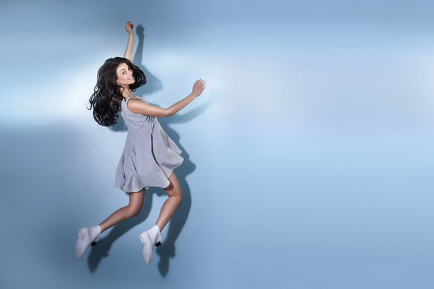 Smiling beautiful brunette woman jumping. - Foto, Imagem