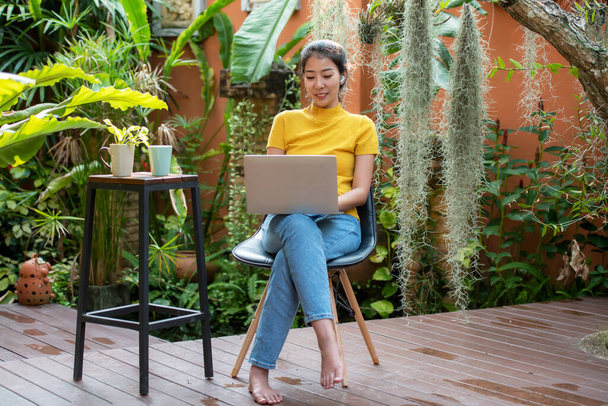 Young people work from home with laptop and drinking coffee in morning relax at home. Asia woman meeting conference connect online with office.  Business and Technology Concept - 写真・画像