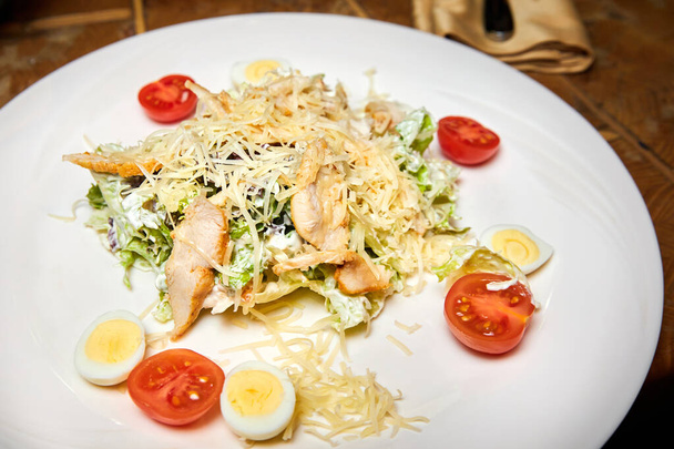 Csirkemell saláta parmezán sajttal, tojással és paradicsommal. Közelkép, szelektív fókusz - Fotó, kép