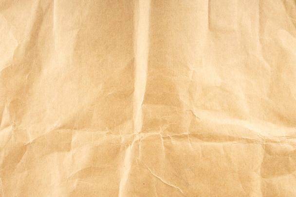 Kézműves papír. Gyűrött barna karton papír textúra. Régi gyűrött újrahasznosított papír textúra, bézs színű. Barna háttér - Fotó, kép