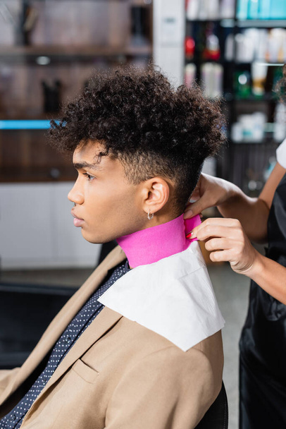 Африканский американский парикмахер использует бумагу на клиента в салоне  - Фото, изображение