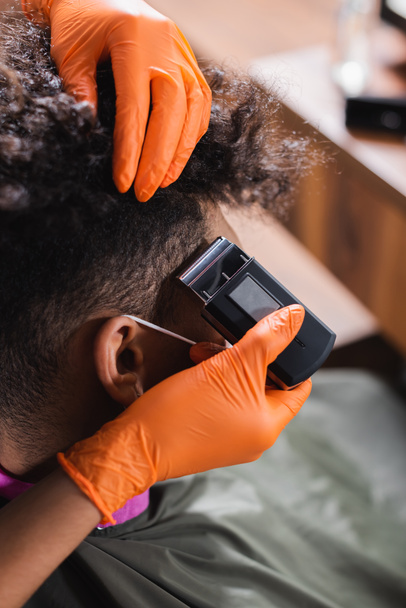 アフリカ系アメリカ人美容師でラテックス手袋トリミング髪の男  - 写真・画像