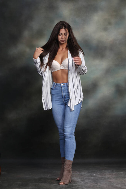 Attractive, sexy muscular brunette caucasian girl posing in studio on isolated background. Style, trends, fashion concept. - Photo, Image