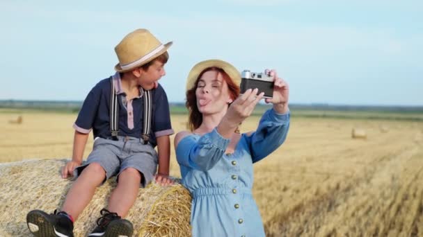 mulher com seu filho se divertir mostrando línguas uns aos outros e são fotografados na câmera retro - Filmagem, Vídeo