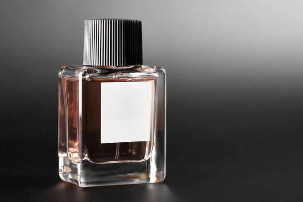 Een flesje parfum. Volledige pot parfum op een donkere achtergrond. - Foto, afbeelding