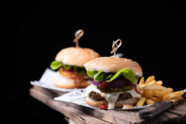 Homemade hamburger or burger with french fries on wooden table. Close up - Fotoğraf, Görsel