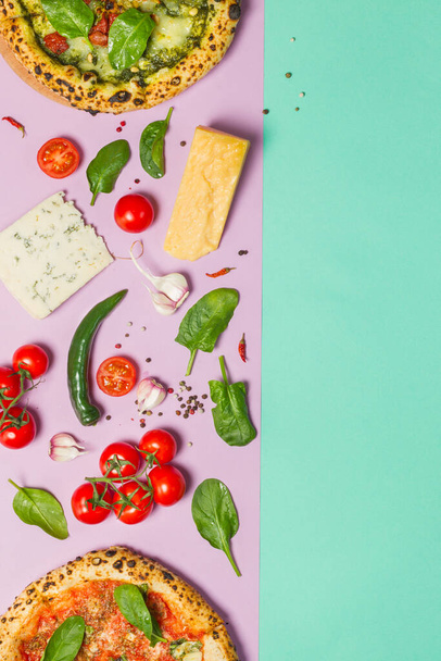 Diseño creativo con pizza marinara y margherita bianca, tomates cherry, queso parmesano, queso brie, hojas de espinaca y ajo. Sobre un fondo de papel de color con espacio para texto, marco vertical - Foto, Imagen