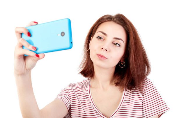 白い背景に孤立したスマートフォンで自撮り写真を作る若い魅力的な女性の肖像画 - 写真・画像