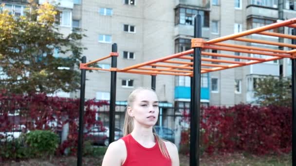 mladá fit blond žena s culíkem v červené top stojící na sportovním hřišti - Záběry, video