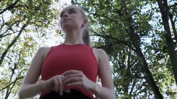 Junge, fitte Läuferin in Sportkleidung steht an sonnigem Tag im Herbstpark - Filmmaterial, Video