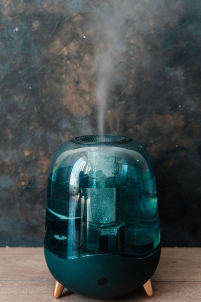Modern air humidifier on a dark background. Humidifier spreading steam into the living room. - Photo, Image