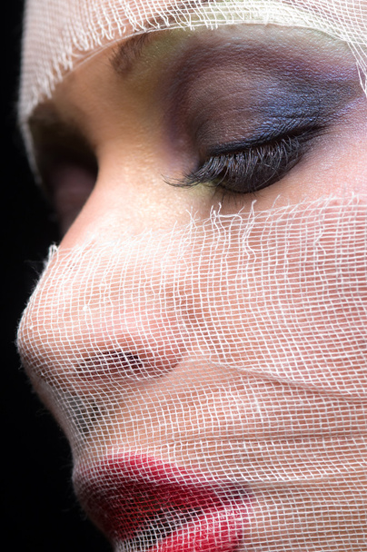 γυναικείο πρόσωπο με φωτεινό μακιγιάζ σε Γάζα επίδεσμο - Φωτογραφία, εικόνα
