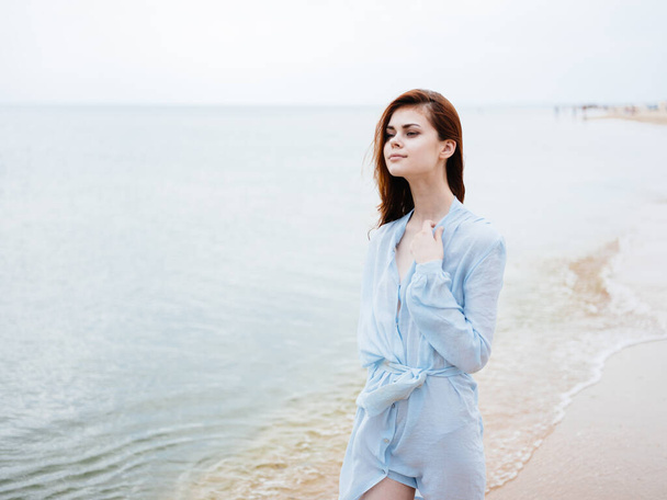 woman in blue dress running on the seashore - Zdjęcie, obraz