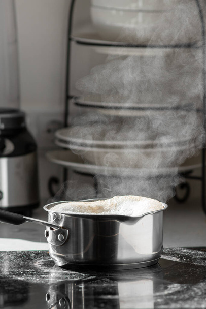 brodo bollente con un vapore in una pentola su una stufa elettrica in cucina.  - Foto, immagini