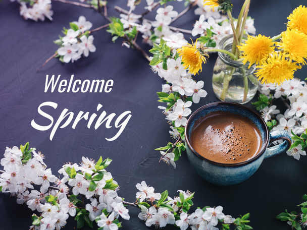 Ласкаво просимо весною, горнятко ароматичної кави і цвіту на столі. - Фото, зображення