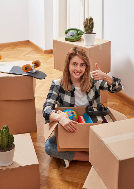 Mujer joven con cajas de cartón en un nuevo apartamento - Foto, imagen